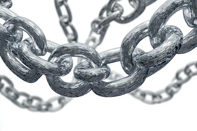 Close-up of interlinked metallic chains with reflective texture on blurred white background