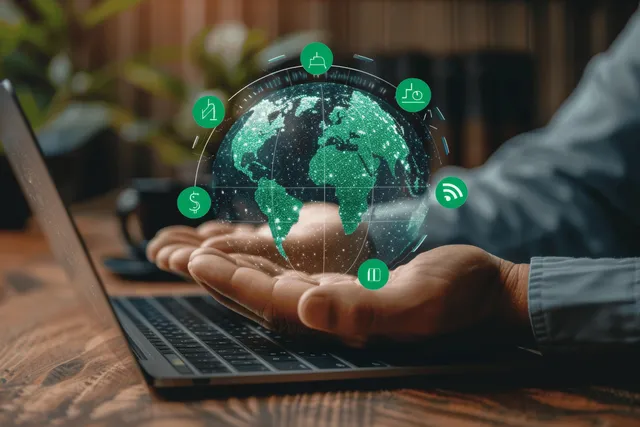 Hands over a laptop with a glowing virtual Earth hologram showing green climate and sustainability icons.