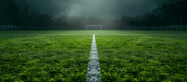 Soccer field center line recedes into neon fog under a dark night sky with the goal in the distance.