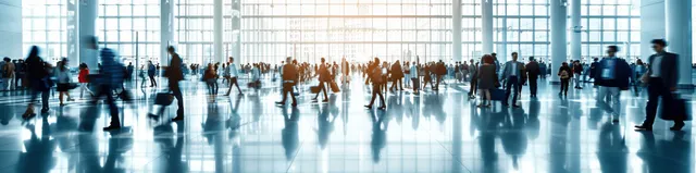Business people with motion blur crossing a bright conference hall under panoramic windows