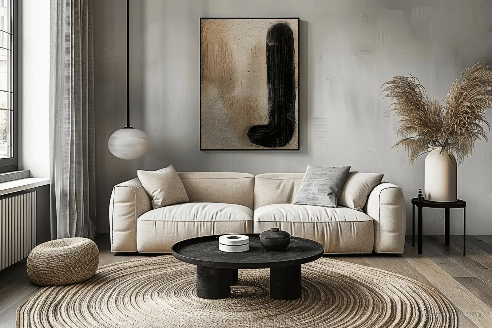 Beige sofas sit behind a black coffee table on a striped rug beneath a framed abstract wall artwork.