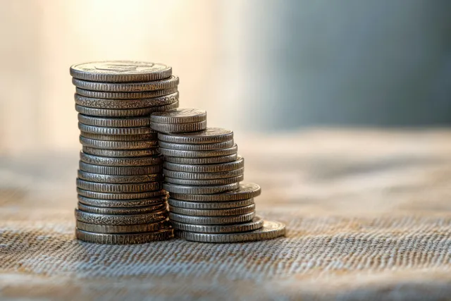 Silver coin stacks on textured fabric with soft natural light and shallow background blur