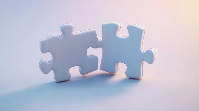 Two interlocking puzzle pieces, one white and one light blue, on a soft gradient background with subtle shadows.