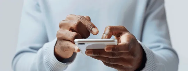 Adult man’s hands holding a smartphone and typing a message on a white background.