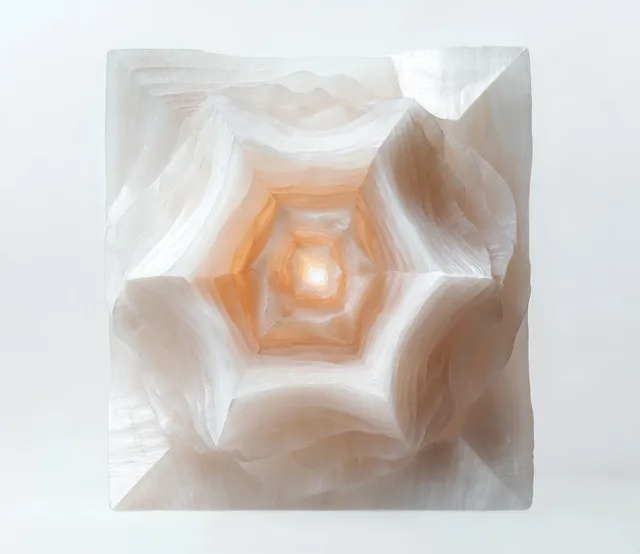 Translucent white crystal close-up with layered geometric star shapes and a soft inward glow.