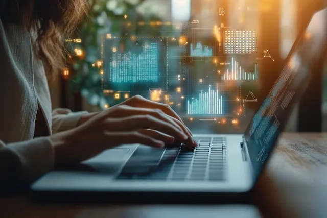 Person typing on a laptop with glowing financial charts and data indicators overlaid in a modern office.