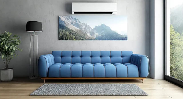 Blue sofa in minimalist living room with rug, lamp, and mountain artwork by large window