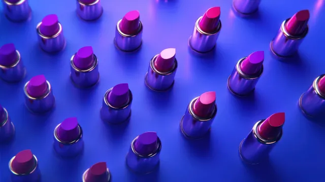 Purple and pink lipsticks arranged in neat rows on a vivid blue background with glossy highlights.