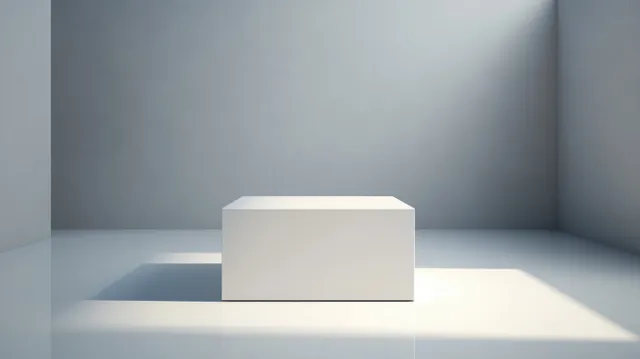 A white cubic pedestal stands in an empty gray room with a sharp shadow on the floor.