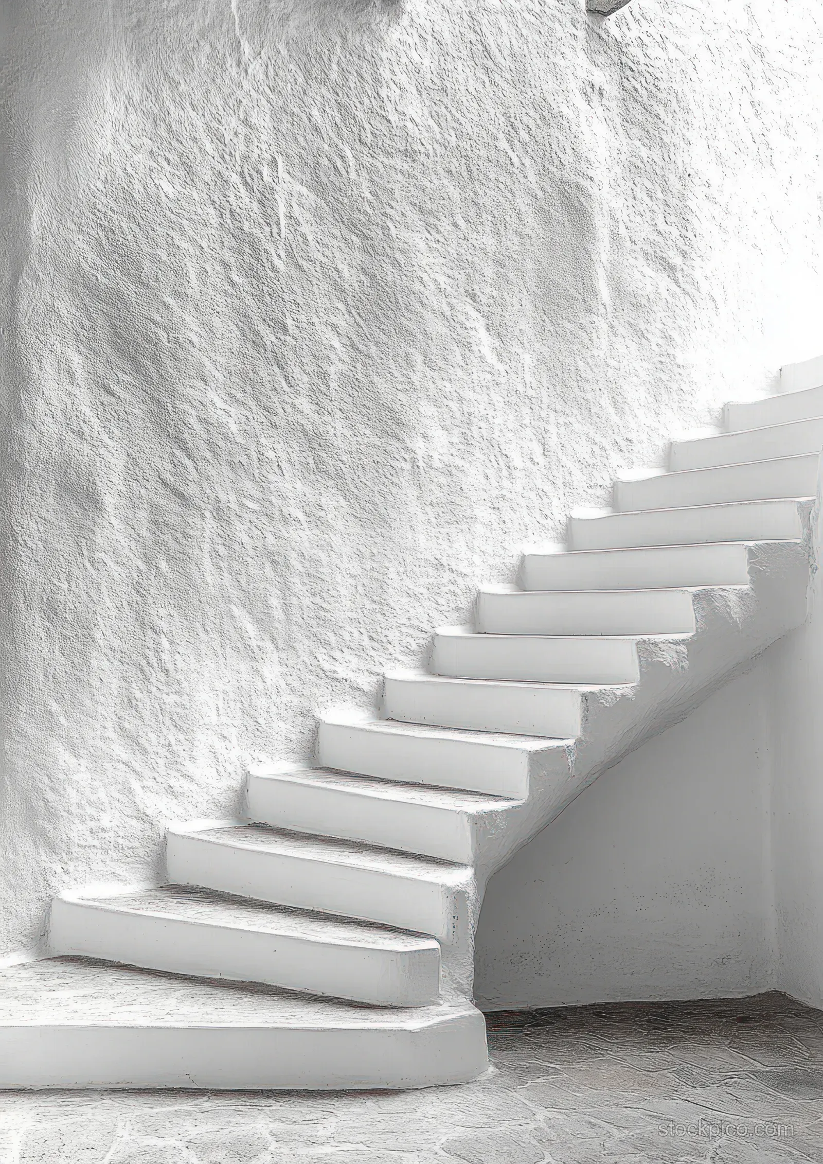 White curved staircase ascends along a textured wall with stone floor and soft daylight shadows.