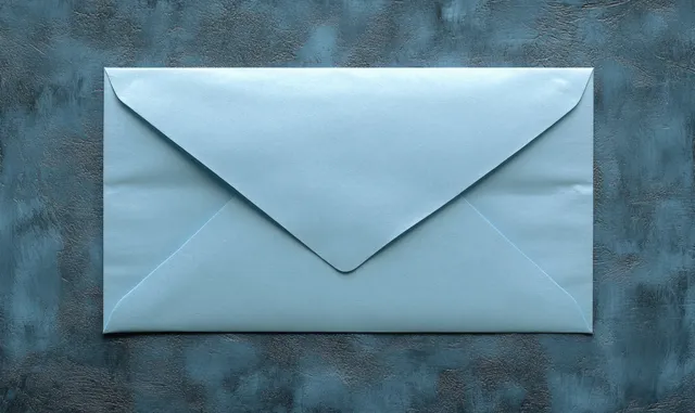 Light blue envelope resting on textured dark blue background with crisp fold details