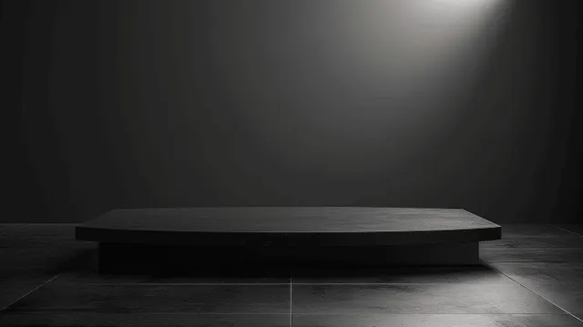 A black wooden shelf pedestal table sits in a dark studio under a spotlight with soft shadows.