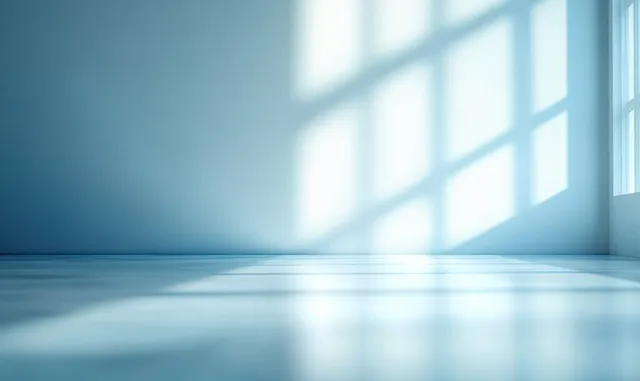 Empty minimalist room with reflective floor and window shadows across blue walls