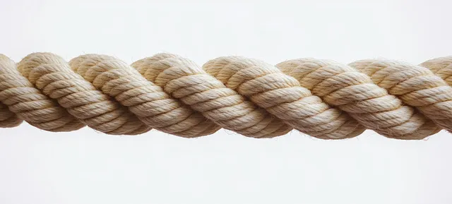 Thick twisted beige rope with visible fibers isolated on a plain white background.