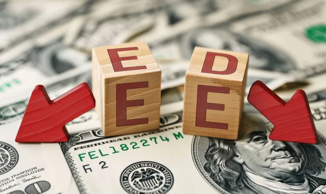 US dollar banknotes with green up and red down arrows and stacked letter blocks suggesting changing interest rates.