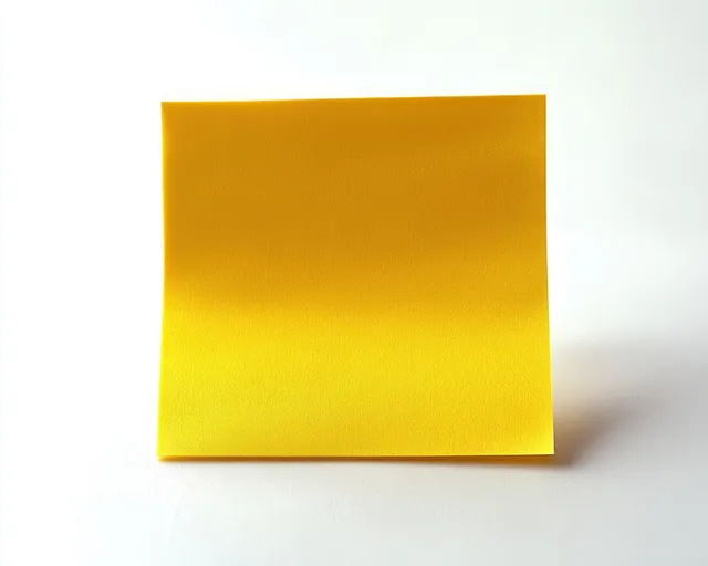 A yellow sticky note pad rests on a white surface with a soft shadow and visible paper texture.
