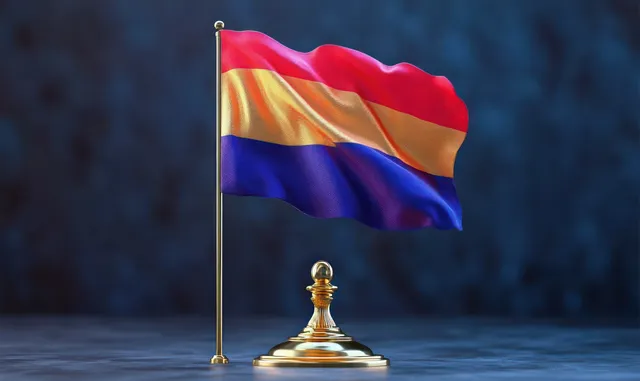 A small striped flag waves on a gold stand while the background remains dark and blurred.