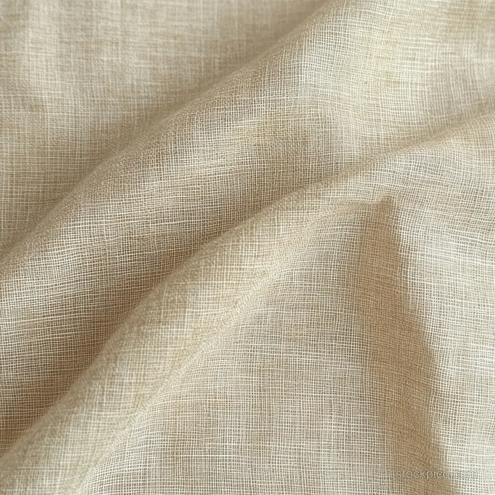 Beige woven fabric close-up with wrinkled folds and visible fine threads under soft lighting.