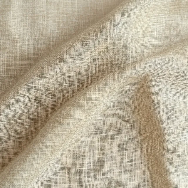 Beige woven fabric close-up with wrinkled folds and visible fine threads under soft lighting.