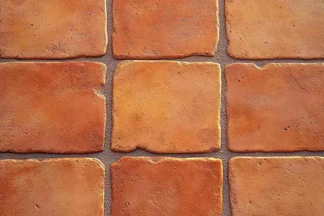 Terracotta square floor tiles in a grid pattern with rough matte texture and reddish-orange tones.