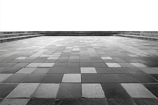 Empty stepped terrace with large square gray stone tiles across the ground and surrounding stone steps.