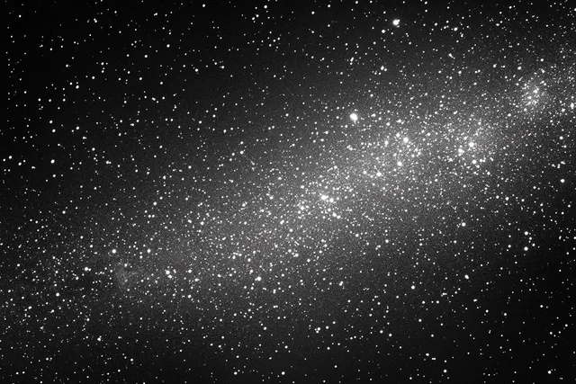 Star-filled galaxy across deep black space, countless bright points and faint cosmic dust