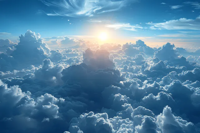 Sunrise shining over thick clouds in a wide blue sky.
