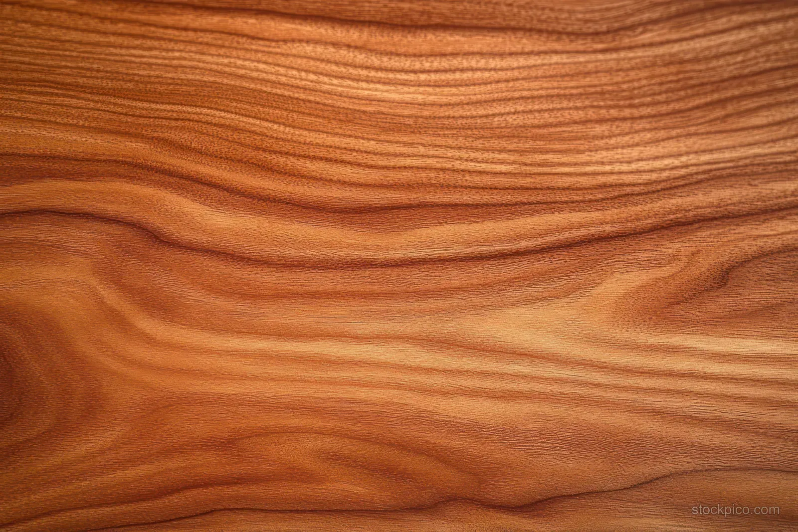 Polished cherry wood surface with flowing grain lines and warm brown tones filling the frame.