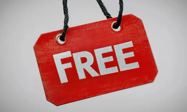 Red wooden free tag with bold white FREE text hanging by black string on a light background.