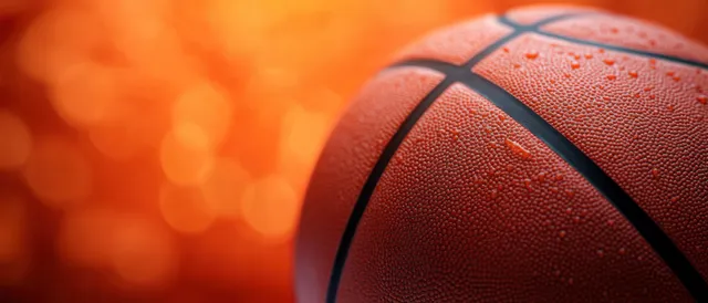 Wet basketball close-up with water droplets and orange bokeh background