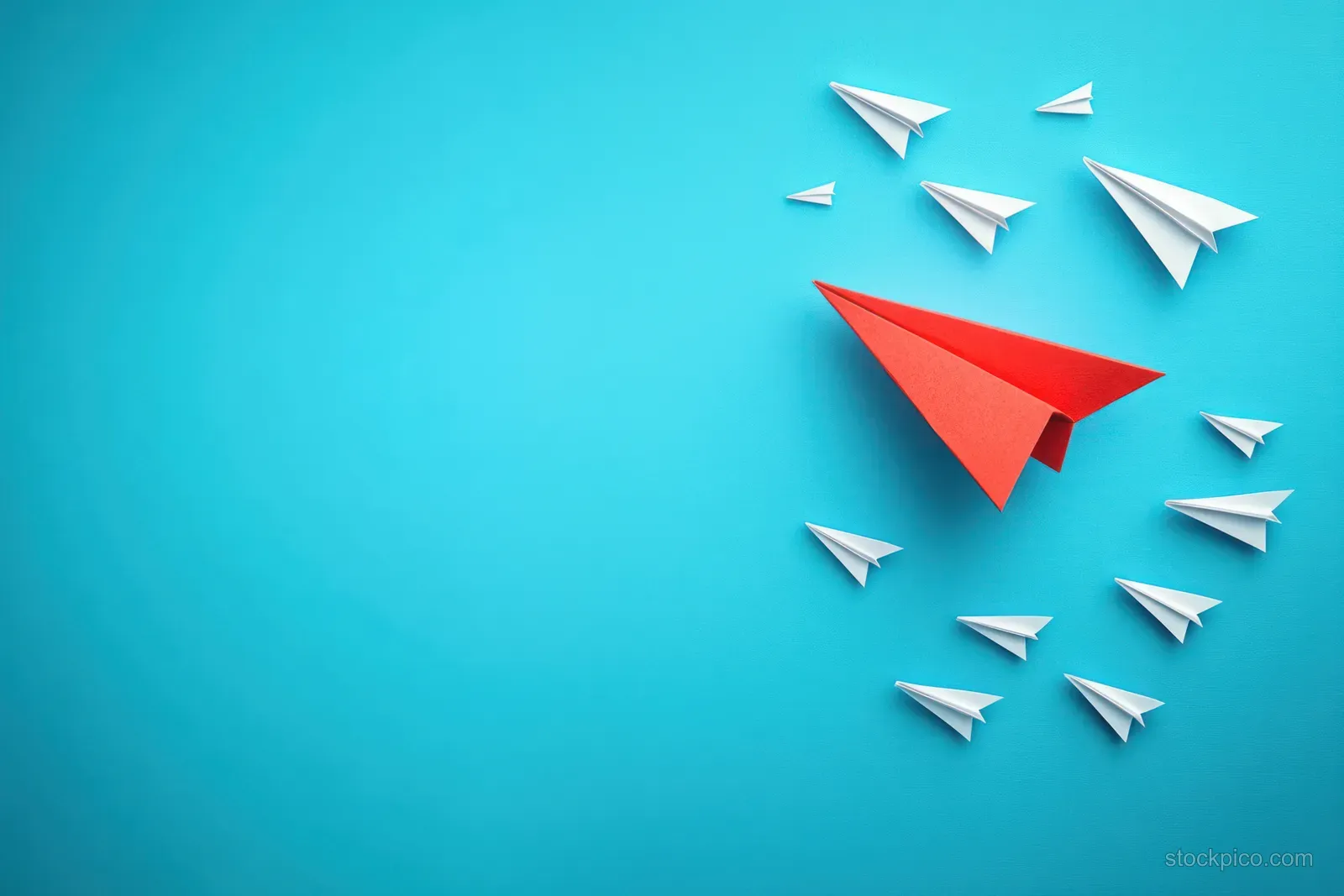 A red paper airplane stands out among white paper planes flying on a blue background.