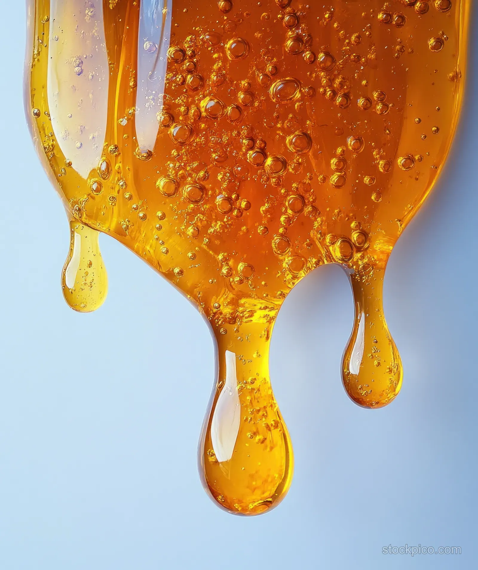 Golden oil droplets spill from a fish oil capsule edge onto a white background in a viscous stream.