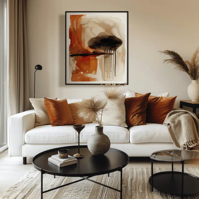 White sofa with terracotta pillows sits beside a framed abstract poster above a black coffee table in a bright living room.
