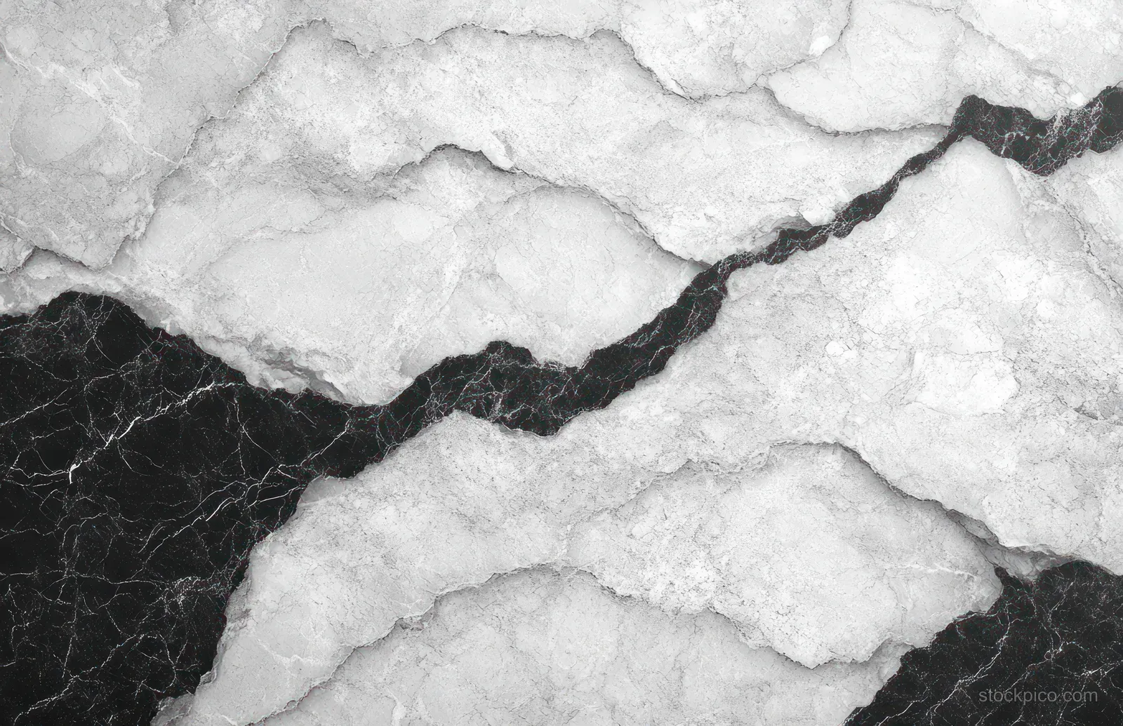 Close-up of a white marble surface with bold black veins forming crack-like abstract patterns.