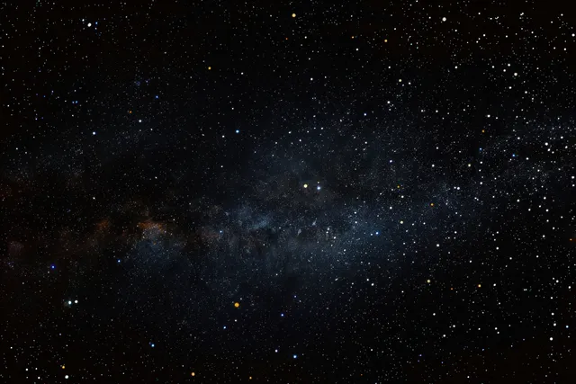 Countless stars scattered across a dark night sky with a faint Milky Way band.