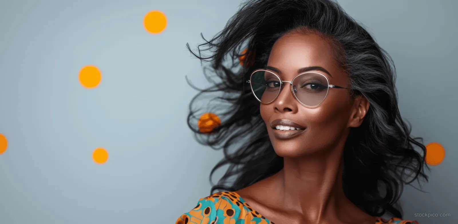 Woman wearing round sunglasses and colorful patterned outfit posing before a retro dotted abstract backdrop.