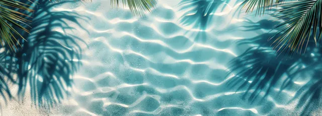 Top view of tropical pool ripples with palm leaf shadow on sandy beach background