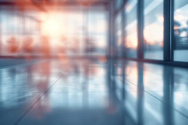 Bright office hallway with panoramic windows, blurred city reflections, and light-filled perspective