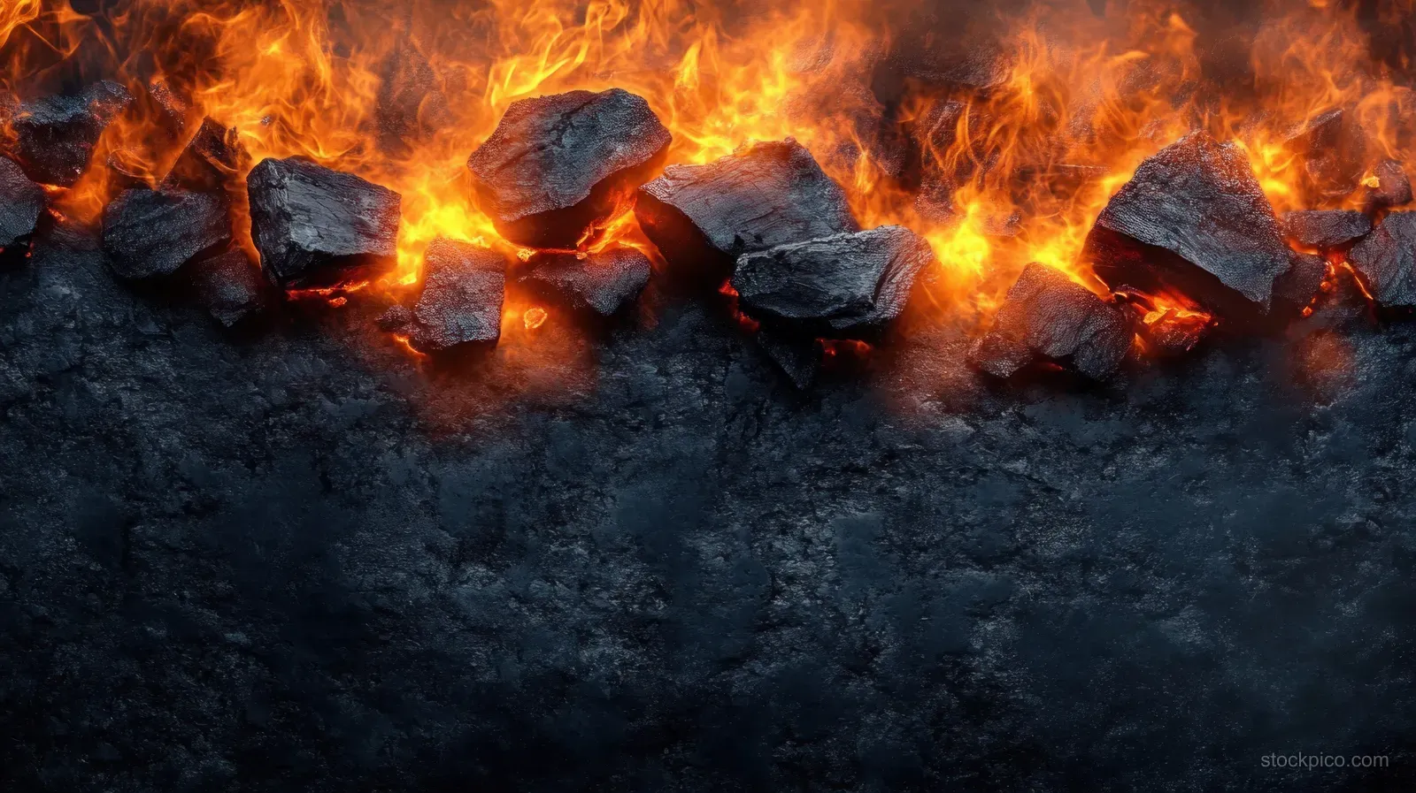 Glowing burning charcoal coals with orange flames and sparks over a dark smoky surface.