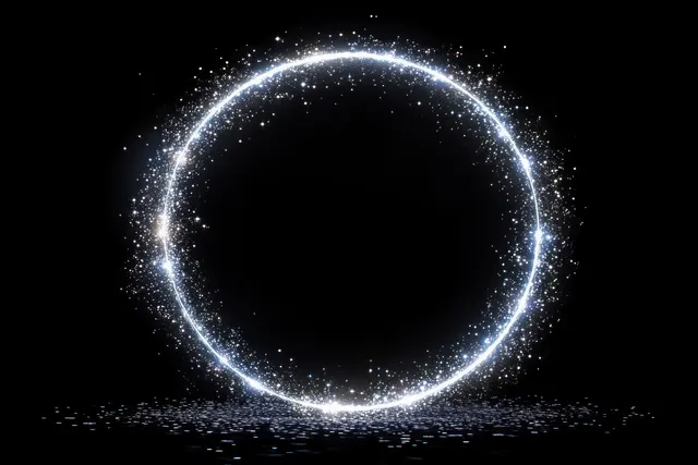 A glowing ring of white sparkling particles forms a halo on a black background with a bright reflected glow below.