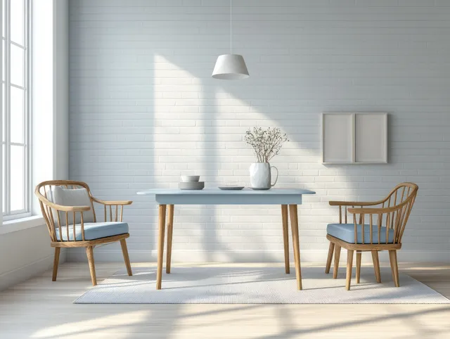 Sunlit dining nook with a pale blue table, two wooden chairs, and minimal blue-white decor against brick walls.