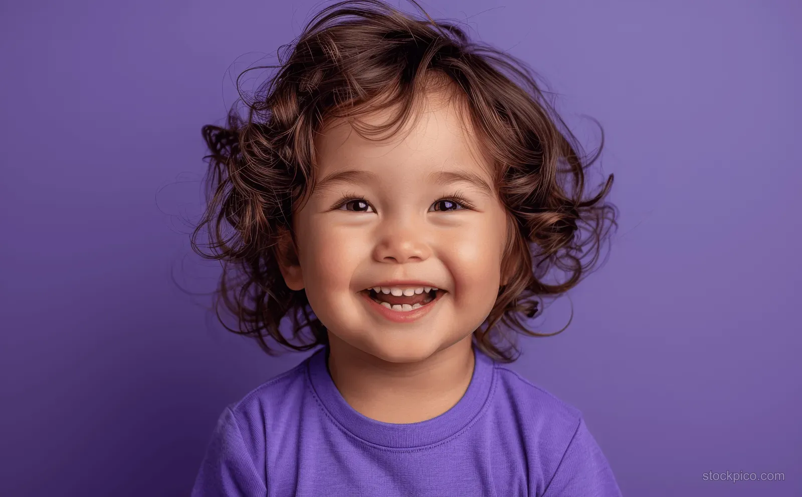 Asian toddler boy laughing in a purple T-shirt during a studio portrait on a solid violet background.