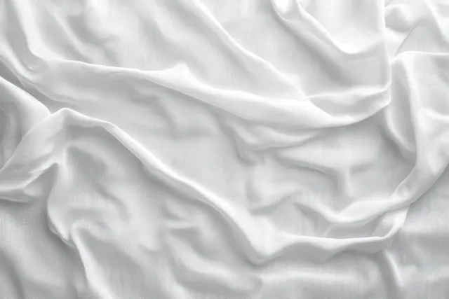 Wrinkled white fabric background with soft natural light and subtle shadow creases