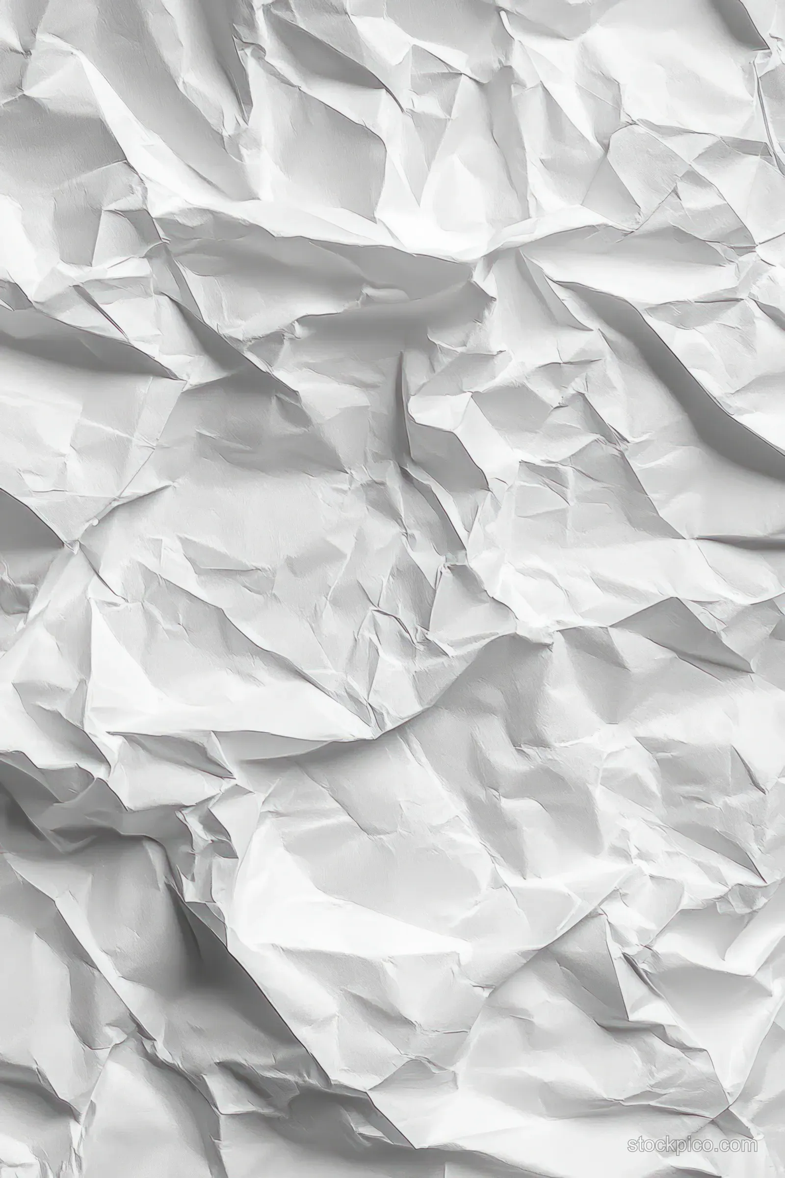 Close-up of crumpled white paper with detailed folds and creases casting distinct shadows across a textured surface.