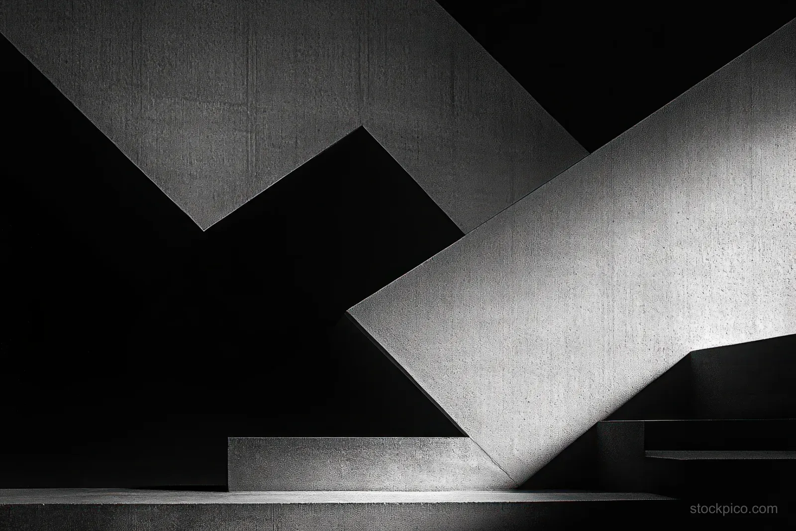 Monochrome minimalist concrete interior where diagonal beams cast sharp geometric shadows across steps.