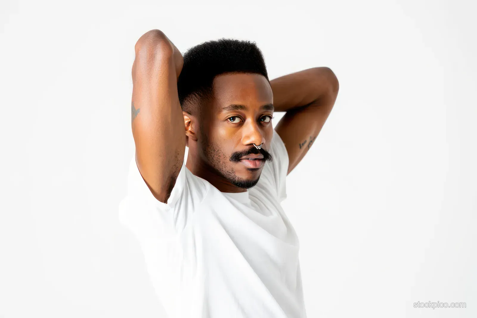 Confident Young Man With Short Afro Hairstyle in White T-Shirt, Studio Portrait Against White Background