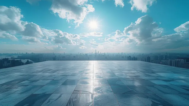 Rooftop terrace with empty concrete floor leading to city skyline under blue clouds
