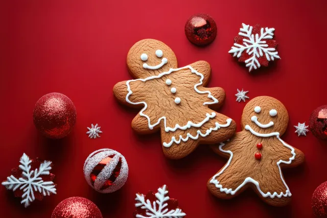 Gingerbread cookies arranged on red holiday backdrop with snowflake decorations and candy balls