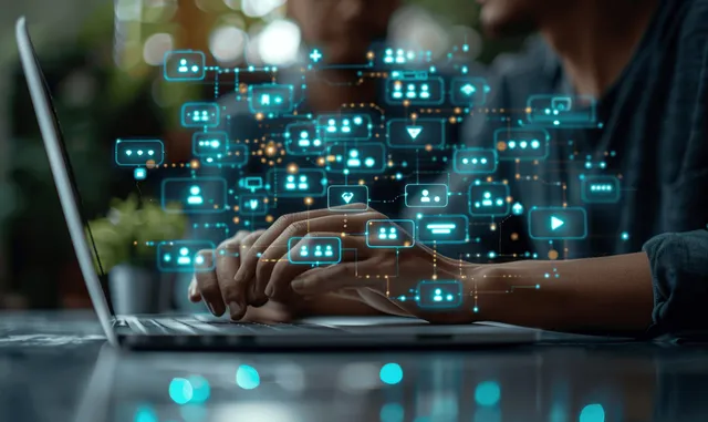 A person types on a laptop with glowing virtual chat bubbles and CRM support icons overlaid in an office.