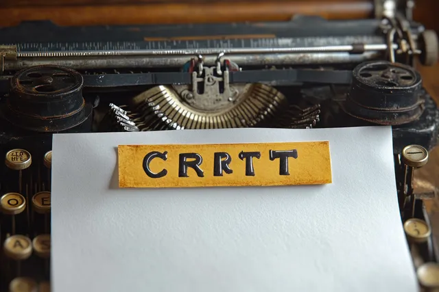 Close-up of a vintage typewriter with a paper strip showing typed letters and chrome roller details.